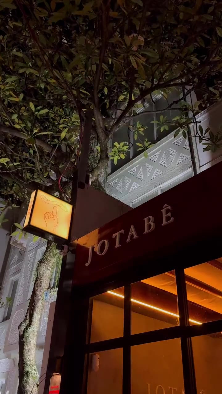 A fachada da Jotabê à noite, com o letreiro iluminado